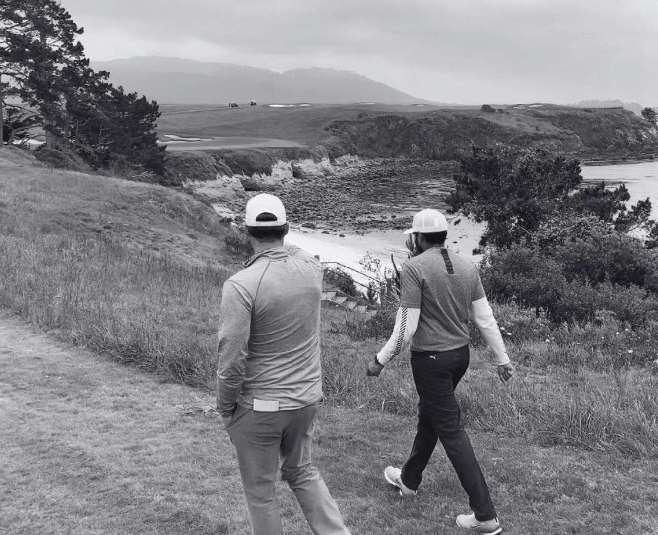 Shankar and Ryan walking the coastal course, overlooking the cliffs and bunkers below